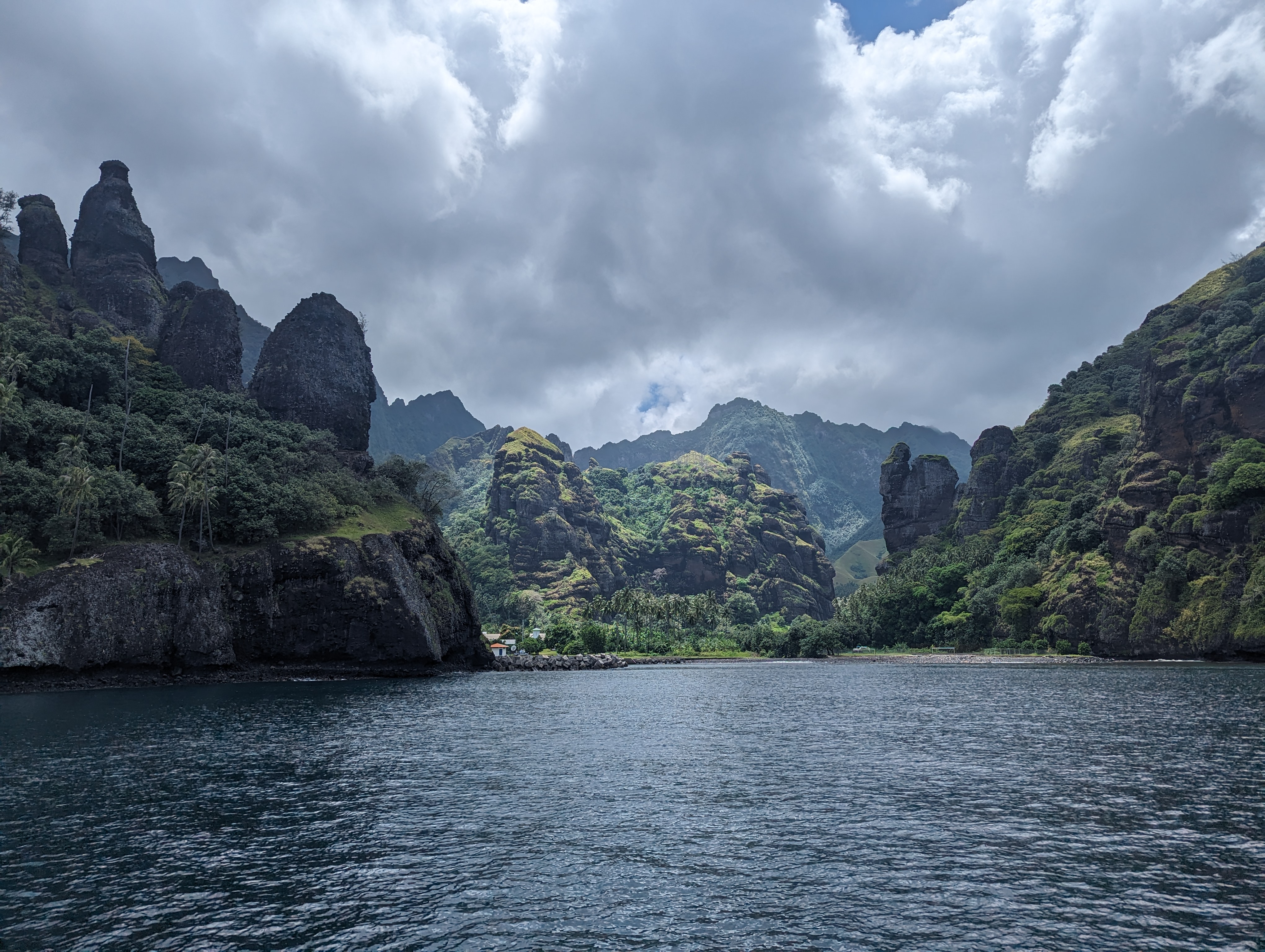 Dramatic volcanic peaks rising from the sea under moody clouds